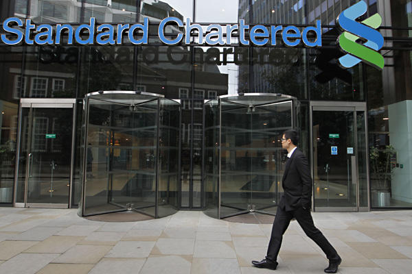 A man walks past Standard Chartered bank's headquarters building in London Tuesday. Photo by AP.