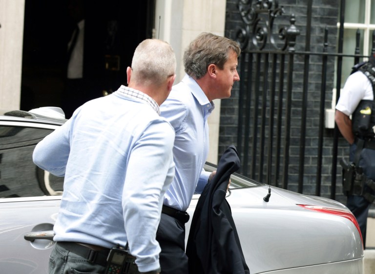 Britain's Prime Minister David Cameron arrives back in Downing Street, London, after cutting short his vacation in Cornwall on Wednesday, Aug. 20, 2014.(AP Photo/Yui Mok/PA)