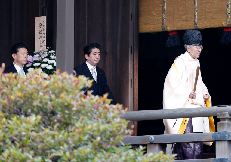 Japanese Prime Minister Shinzo Abe, center, follows a Shinto priest to pay respect for the war dead at Yasukuni Shrine in Tokyo Thursday, Dec. 26, 2013. Abe visited Yasukuni war shrine in a move sure to infuriate China and South Korea. The visit to the shrine, which honors 2.5 million war dead including convicted class A war criminals, appears to be a departure from Abe's 