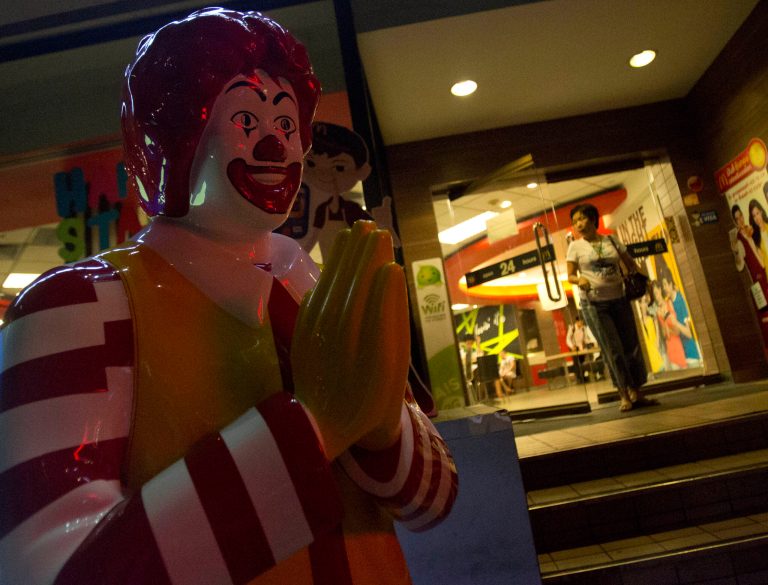 A customer leaves a McDonald's restaurants in Bangkok, Thailand, Friday, May 30, 2014. The burger chain's famous golden arches have become part of the iconography of anti-coup protests and it is warning activists to 