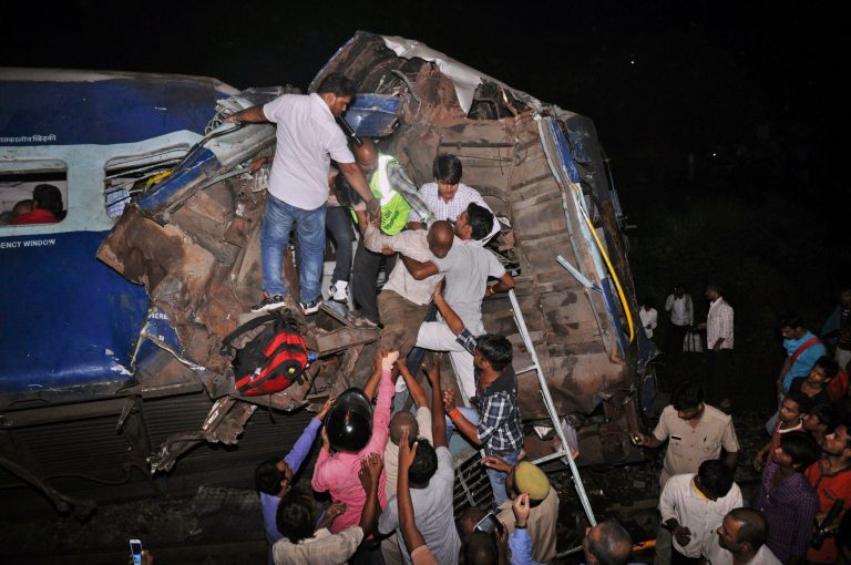 In this Sept. 30, 2014 photo, passengers are rescued from a damaged train near Gorakhpur city, India. A train overshot a stop signal and plowed into another express passenger train in India's northern Uttar Pradesh state, killing 12 people and injuring dozens, officials said Wednesday. (AP Photo)