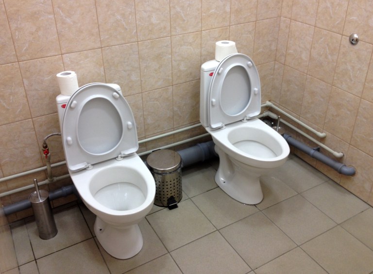 In this photo taken Saturday, Feb. 1, 2014, two female toilets sit side by side at the security screening facility outside the Main Press Center at the 2014 Winter Olympics, in Sochi, Russia. Side-by-side toilets in a single bathroom caused a social media sensation last month when they were discovered at the biathlon course of the Sochi Olympics, swiftly becoming a national joke in Russia. The Sochi organizing committee initially denied knowledge of the second twin toilet, and it has not been able to say whether the loo-loo was built by design or resulted from an error during the plumbing process. (AP Photo)