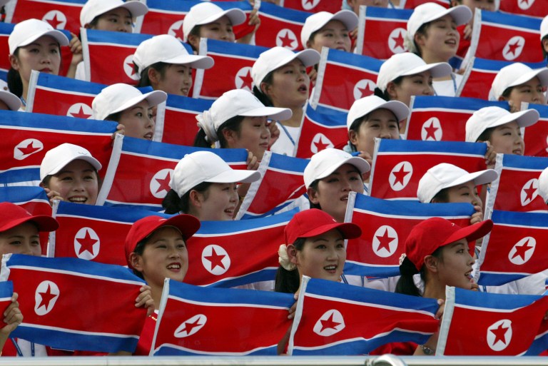 In this photo taken on Thursday, Aug. 28, 2003, North Korean women hold national flags to cheer at the Daegu Universiade Games in Daegu, south of Seoul, South Korea. North Korea said Monday, July 7, 2014, it will send a cheering squad to the coming Asian Games in rival South Korea that its athletes plan to attend.(AP Photo/Lee Jin-man)
