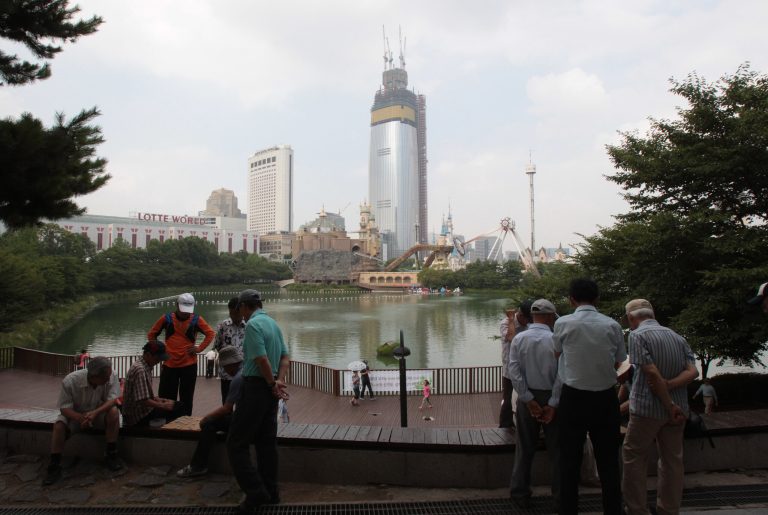 In this July 8, 2014, residents play Chinese chess with the Lotte World Tower, center, under construction in the background near Seokchon Lake in Seoul, South Korea. Plans for the super-high tower first surfaced in 1995 and it took another 15 years to get a green light after the Air Force objected to it as a risk to a nearby military airport used for VIP flights. Now it faces new doubts as South Korea reels from the Sewol ferry sinking in April that killed hundreds of teenagers. The disaster provoked a scathing reassessment of an ethos of economic progress first, safety last that was largely unquestioned over several decades as the country rapidly industrialized. (AP Photo/Ahn Young-joon)