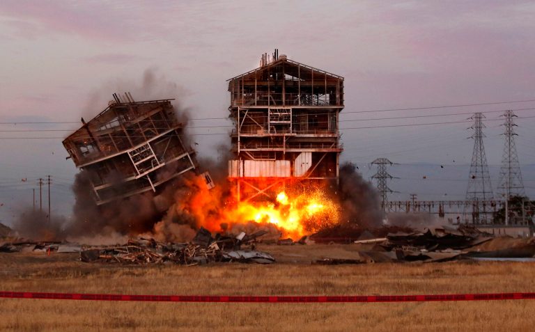 In this Aug. 3, 2013, photo, an explosion knocks down one of the remaining towers at the old Kern Power Plant, in Bakersfield, Calif. (AP/The Bakersfield Californian, Autumn Parry)