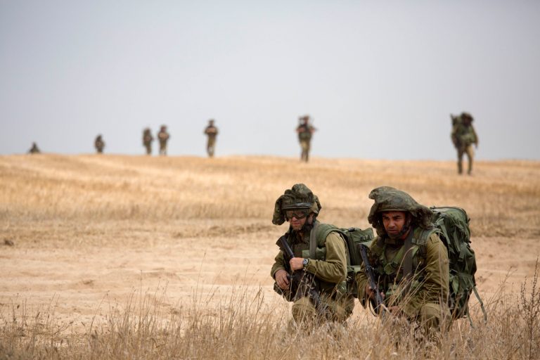 Israeli soldier march during a drill near Israel and Gaza border, Tuesday, July 22, 2014. Israeli airstrikes pummeled a wide range of targets in the Gaza Strip on Tuesday as the U.N. chief and the U.S. secretary of state began an intensive effort to end more than two weeks of fighting that has killed hundreds of Palestinians and dozens of Israelis.(AP Photo/Tsafrir Abayov)