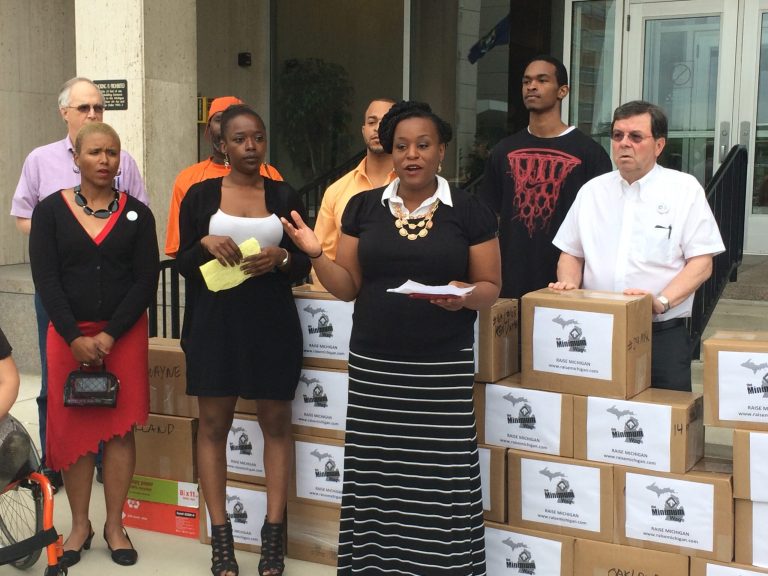 Members of a coalition working to raise Michigan's minimum wage to $10.10 an hour, from the current $7.40 an hour, prepare to file more than 300,000 signatures Wednesday, May 28, 2014,  in Lansing, Mich., for a measure to appear on the November ballot. The signature submission comes one day after Gov. Rick Snyder signed legislation raising the minimum wage to $9.25 an hour by 2018. (AP Photo/Emma Fidel)