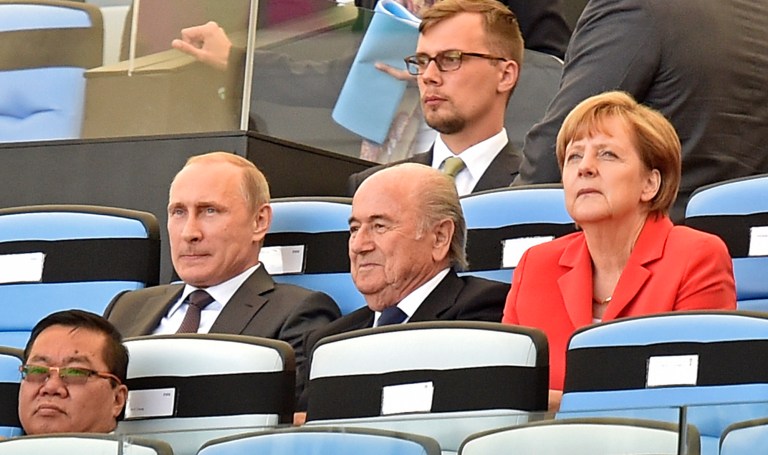 Russia's President Vladimir Putin, left, FIFA President Sepp Blatter, center, and Germany's Chancellor Angela Merkel, right, watch the opening ceremony of the World Cup final soccer match between Germany and Argentina at Maracana Stadium in Rio de Janeiro, Brazil, Sunday, July 13, 2014. (AP Photo/Martin Meissner)