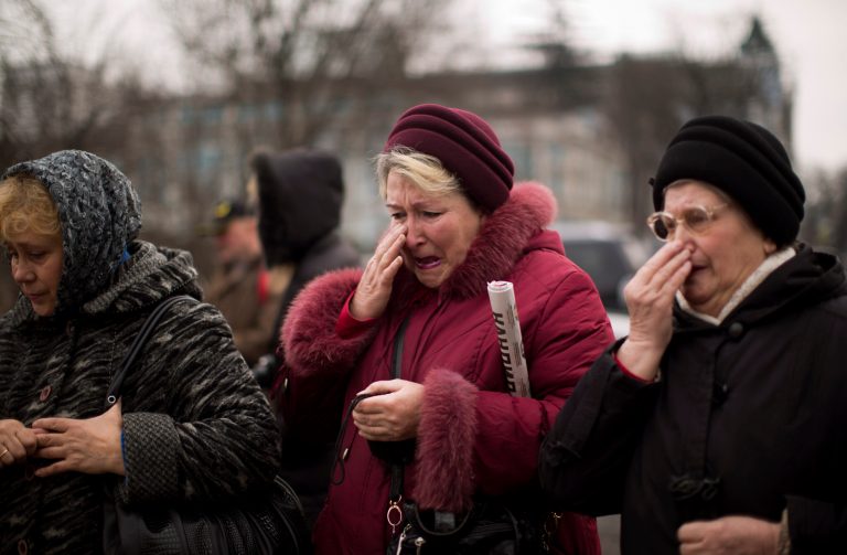 Women show emotion  at a memorial for the people killed in clashes with the police at Kiev's Independence Square, the epicenter of the country's current unrest, Ukraine, Thursday, Feb. 27, 2014. Ukraine put its police on high alert after dozens of armed pro-Russia men stormed and seized local government buildings in Ukraine's Crimea region early Thursday and raised a Russian flag over a barricade. (AP Photo/Emilio Morenatti)