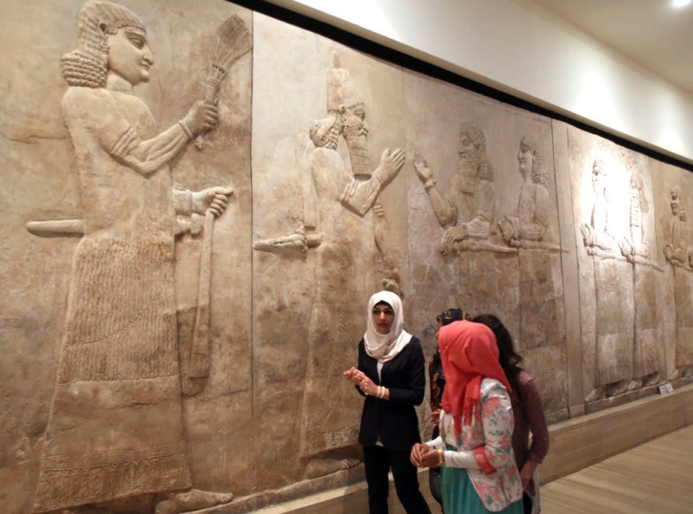 People observe ancient artifacts at the Iraqi National Museum after its reopening in the wake of the recent destruction of Assyrian archaeological sites by the Islamic State group in Mosul, as they visit the museum in Baghdad. (AP Photo/Karim Kadim, File)