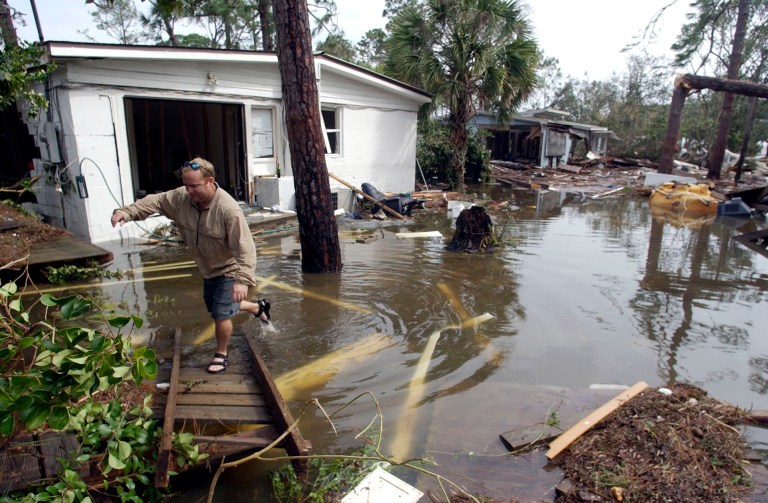 Keith Sawyer checks the damage to his home caused by Hurricane Ivan, Sept. 16, 2004. (AP File Photo/John Bazemore)