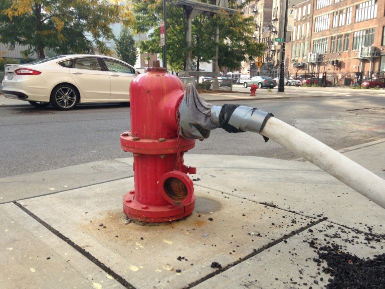 A makeshift water connection to a fire hydrant has been fashioned Thursday, Oct. 2, 2014 outside the 1515 Broadway coffeehouse in Detroit, Mich. A system of plastic pipe, garden hoses, duct tape and towels is providing water service to the coffeehouse and an adjoining jewelry store as city repairs to the water system serving the businesses are on hold, officials said.  (AP Photo/Mike Householder)