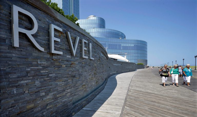 In this Wednesday July 23, 2014 photograph, People walk past the Revel Casino Hotel in Atlantic City, N.J. The Revel Casino Hotel will close its doors on Sept. 10, 2014 after failing to find a buyer in bankruptcy court, company officials announced Tuesday, Aug. 12, 2014. (AP Photo/Mel Evans)