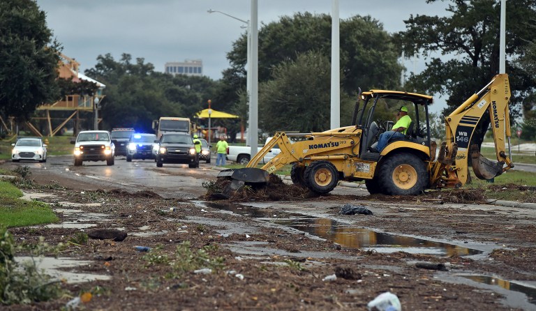 Biloxi public works employees clear debris from U.S. 90 in Biloxi Sunday, Oct. 8, 2017, after Hurricane Nate made landfall on the Gulf Coast. (Justin Sellers/The Clarion-Ledger via AP)