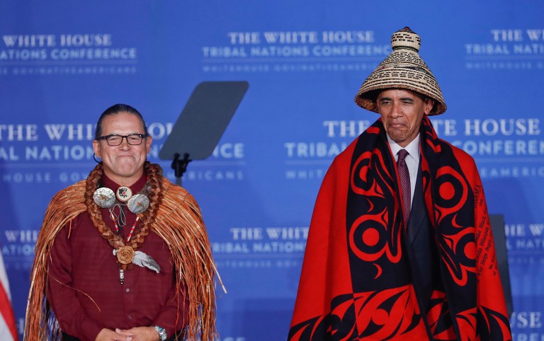 President Obama wears a blanket and hat given to him by Brian Cladoosby, left, President of National Congress of American Indians, during the 2016 White House Tribal Nations Conference, Monday, Set. 26, 2016, at the Mellon Auditorium in Washington. (AP Photo/Pablo Martinez Monsivais)