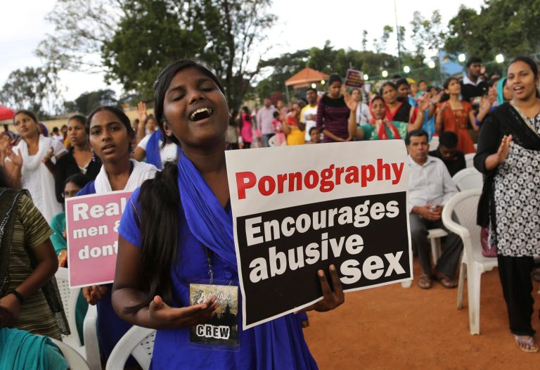 An Indian Christian girl holding a placard denouncing pornography sings during a prayer meeting after a protest rally in Bangalore, India, Sunday, Aug. 31, 2014. (AP Photo/Aijaz Rahi)