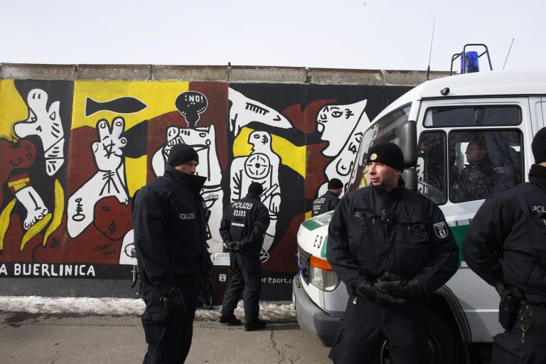 Police officers guard in front of a remaining part of the Berlin Wall in Berlin on Wednesday, March 27, 2013. Work crews backed by about 250 police have removed portions of the Berlin Wall known as the East Side Gallery to make way for an upscale building project, despite demands by protesters that the site be preserved. Plans to remove part of the 1.3-kilometer (3/4-mile) stretch of wall sparked protests that developers were sacrificing history for profit. (AP Photo/Markus Schreiber)