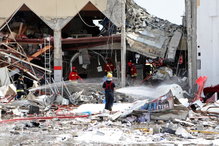Firemen work at the site of an explosion in Doha, Qatar, Thursday, Feb. 27, 2014. A apparent gas explosion Thursday at a restaurant near a filling station in the Qatari capital killed a dozen people and wounded several more, emergency services officials in the energy-rich Gulf nation said. (AP Photo)