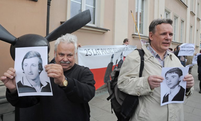 Protesters, holding photos of victims of the communist regime shout slogans against the late Gen. Wojciech Jaruzelski in front of the military cathedral during a Catholic Mass for Jaruzelski, in Warsaw, Poland, Friday, May 30, 2014. Jaruzelski, who died last week, imposed martial law on Poland in 1981 in an attempt to crush Lech Walesa's Solidarity movement but eight years later he allowed the peaceful dismantling of the Soviet-backed system. (AP Photo/Alik Keplicz)