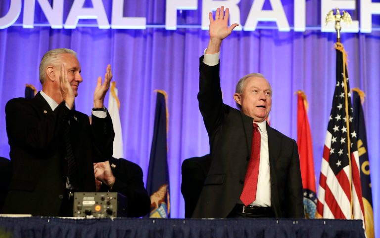 Attorney General Jeff Sessions, right, is applauded at the Fraternal Order of Police convention Monday, Aug. 28, 2017, in Nashville, Tenn. Sessions said President Donald Trump will revive a program that provides local police departments with surplus military equipment such as high-caliber weapons and grenade launchers. (AP Photo/Mark Humphrey)