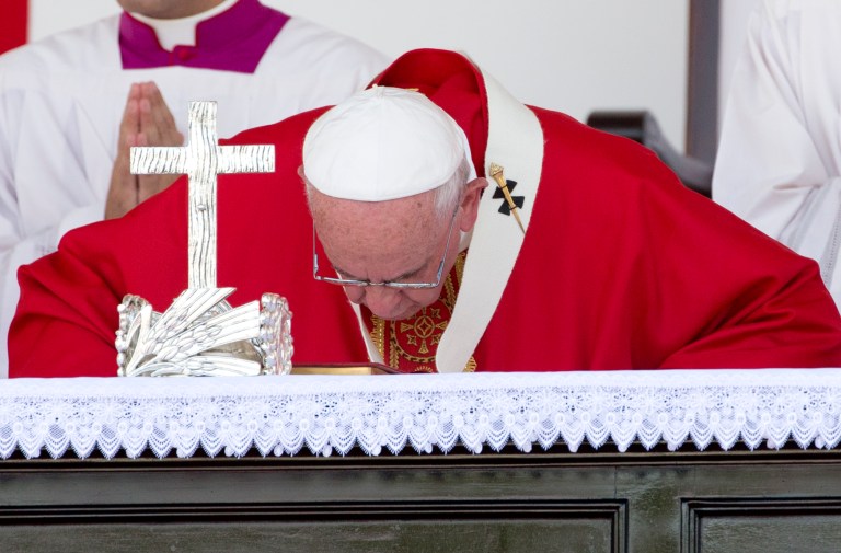 Pope Francis kisses the altar as he arrives to celebrate Mass in Holguin, Cuba. (AP Photo/Alessandra Tarantino)