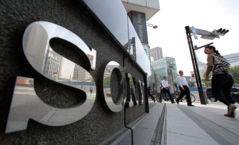 People walk by the Sony building at Ginza shopping district in Tokyo Wednesday, May 14, 2014. Sony Corp. sank to a 138 billion yen ($1.3 billion) quarterly loss, hit by costs from selling its personal computer business and is forecasting more red ink as it struggles to execute a long-promised turnaround. The Tokyo-based maker of the PlayStation 4 game machine, Bravia TVs and Walkman digital player also reported Wednesday a loss of 128.4 billion yen ($1.3 billion) for the fiscal year through March 2014, about three times its loss of 41.5 billion yen the previous year. (AP Photo/Shizuo Kambayashi)