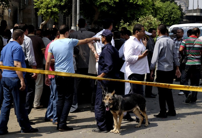 Egyptian security forces inspect the scene after a roadside bomb went off on a busy street in downtown near the foreign ministry, in Cairo, Egypt, Sunday, Sept. 21, 2014. Security officials said the Sunday explosion targeted a police checkpoint near the back gate of the ministry building. Several people were wounded, and senior policemen killed said the officials. (AP Photo/Aly Hazzaa, El Shorouk) EGYPT OUT