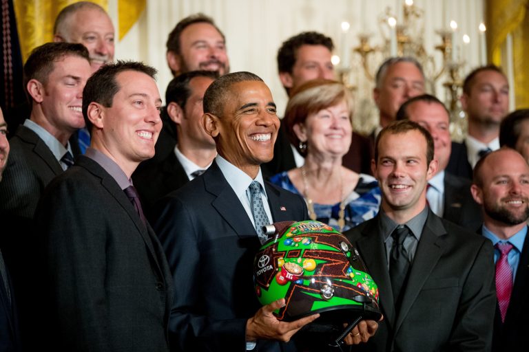 President Barack Obama holds a race car helmet and poses for a photograph with NASCAR race car driver Kyle Busch, left, and members of the Joe Gibbs Racing team during a ceremony honoring the 2015 NASCAR Sprint Cup Series champions, Wednesday, Sept. 28, 2016, in the East Room of the White House in Washington. (AP Photo/Andrew Harnik)