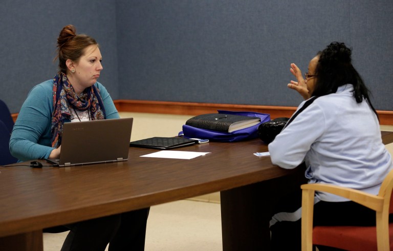A health enrollment navigator helps a woman through the process of signing up for coverage under the Affordable Care Act. The so-called navigators who help uninsured people sign up for insurance under President Barack Obama's health care overhaul would be regulated under a bill in the South Dakota Legislature. (AP Photo/AJ Mast)