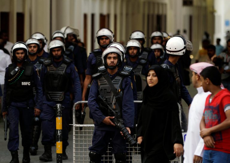   Bahraini shoppers pass a group of riot police in the main market area of downtown Manama, Bahrain, on Wednesday, June 13, 2012. Large numbers of police turned out Wednesday, blocking streets, preventing protesters from gathering and arresting several people who arrived for a march organized by the largest Shiite opposition group, Al-Wefaq, that had been denied permission by authorities. (AP Photo/Hasan Jamali)  