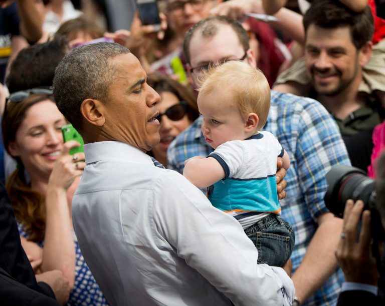 President Barack Obama picks-up a child while greeting members of the audience after speaking on the economy, Friday, June 27, 2014, at Lake Harriet Band Shell in Minneapolis, Minn. Obama was pitching his ideas to boost the America middle class in Minnesota, a state that has already embraced a key component of the president's economic agenda by raising its minimum wage. (AP Photo/Pablo Martinez Monsivais)