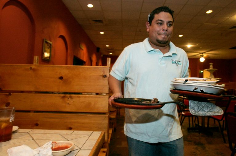 Ruben Castro, owner of La Fiesta Braval, a Mexican restaurant in Laurel, Miss., clears the tables during the lunch rush, Wednesday, Aug. 27, 2008.