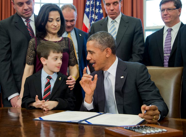 President Barack Obama talks to Jake Miller, left, accompanied by  Ellyn Miller, behind Jake, brother and mother of Gabriela Miller, before signing into law the H.R. 2019, the Gabriella Miller Kids First Research Act, in the Oval Office of the White House in Washington, Thursday, April 3, 2014.   (AP Photo/Manuel Balce Ceneta)