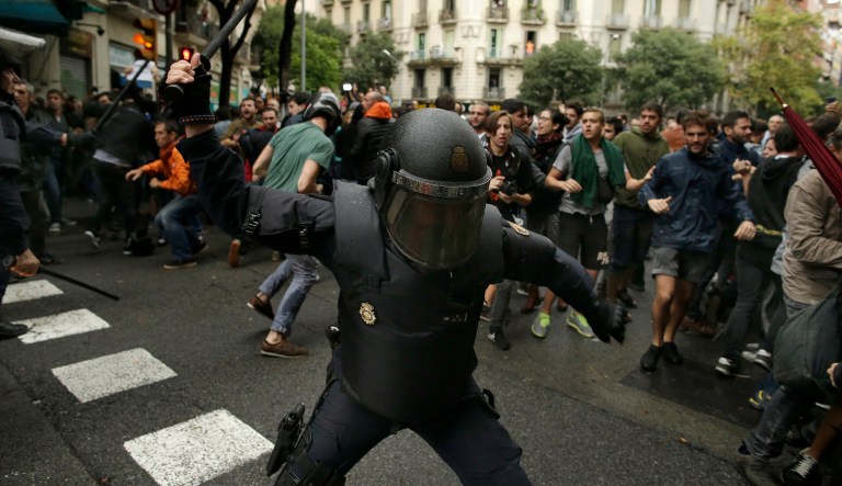Spanish riot police swings a club against would-be voters near a school assigned to be a polling station by the Catalan government in Barcelona, Spain. (AP Photo/Manu Fernandez)