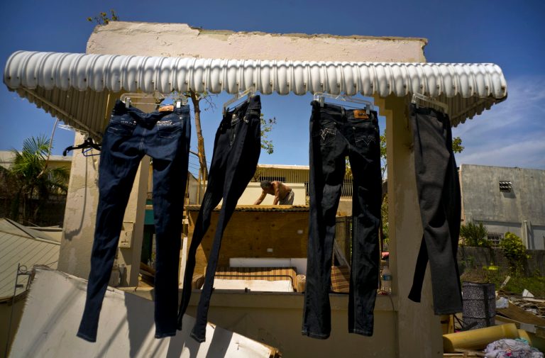 Efrain Diaz Figueroa tries to repair the roof to prevent water from the rains in the remains of the house of his sister destroyed by Hurricane Maria in San Juan, Puerto Rico, Monday, Oct. 9, 2017. (AP Photo/Ramon Espinosa)