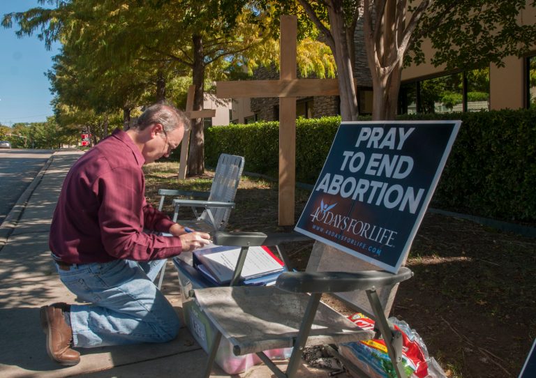 Lee Valerius adds his name to the list of people holding a vigil outside of the Southwestern Women's Surgery Center in Dallas in November following a federal appeals court ruling that allowed most of the state's new abortion restrictions to take effect. (AP Photo/Rex C. Curry)