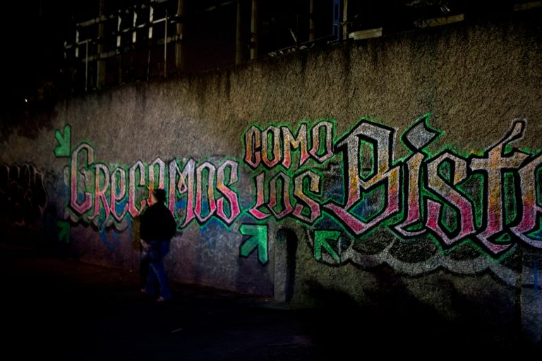 In this April 11, 2014 photo, people walk past graffiti reading in Spanish 
