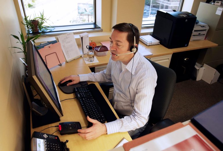 Kirk Postotnik speaks to someone asking about the insurance marketplace at Portico Healthnet in St. Paul, Minn. (AP Photo/Jim Mone, file)