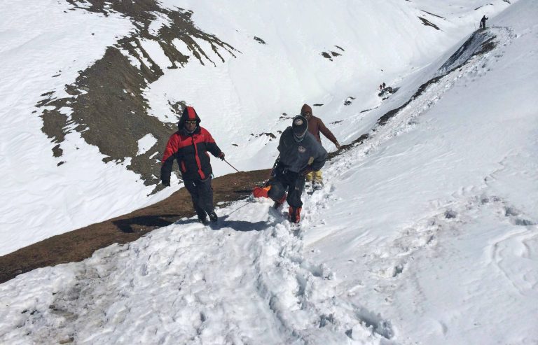 In this handout photo provided by the Nepalese army, rescue team members carry the body of an avalanche victim at Thorong La pass area in Nepal, Friday, Oct. 17, 2014. Rescuers widened their search Friday for trekkers stranded since a series of blizzards and avalanches battered the Himalayas in northern Nepal early this week, leaving at least 29 foreigners and locals dead, officials said. (AP Photo/Nepalese Army)