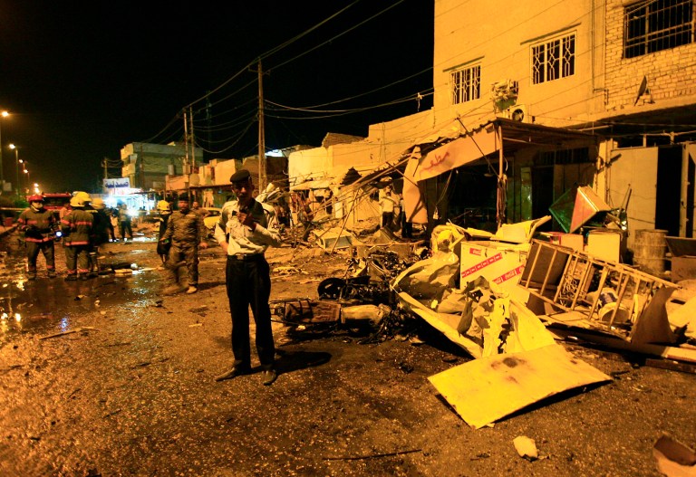 In this photo taken on Wednesday, June 4, 2014 Iraqi security forces inspect the site of a car bomb attack in Hillah, about 60 miles (95 kilometers) south of Baghdad. Iraq is experiencing its worst surge in violence since the sectarian bloodletting that nearly tore the country apart in 2006 and 2007. The U.N. says 8,868 people were killed in 2013. (AP Photo)