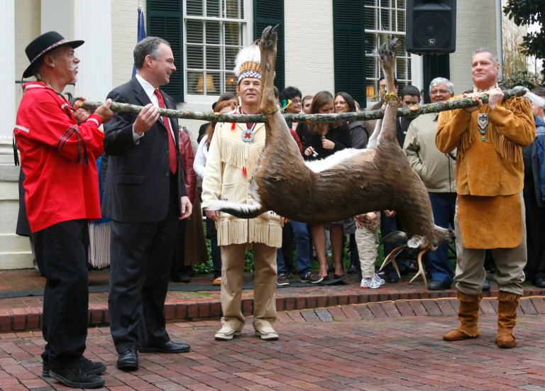 FILE - This Nov. 25, 2009, file photo shows Pamunkey Councilmen Jeff Brown, left, and Gary Miles, hold a deer as their Chief Kevin Brown presents it to Gov. Tim Kaine, second from left, during the annual tax tribute from the Virginia Indians to the Virginia governor in Richmond, Va. Several members of the Congressional Black Caucus are urging the Obama administration to withhold federal recognition of the Pamunkey tribe in southeast Virginia because of its history of banning intermarriage with blacks. (AP Photo/Richmond Times-Dispatch, Alexa Welch Edlund, File)