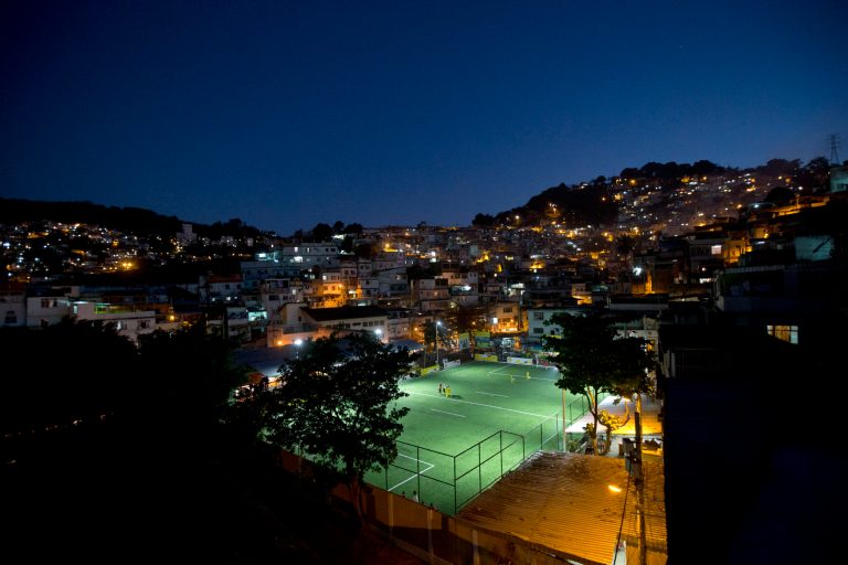 Residents of the Morro da Mineira favela play in the newly installed soccer pitch powered by player's footsteps, in Rio de Janeiro, Brazil, Wednesday, Sept. 10, 2014.  The project, sponsored by British oil giant Shell, has around 200 energy-capturing tiles installed along the width and breadth of the field and covered by a layer of AstroTurf. Working in conjunction with solar panels also installed around the field, the player-powered tiles feed electricity to a system of floodlights overhead. (AP Photo/Silvia Izquierdo)