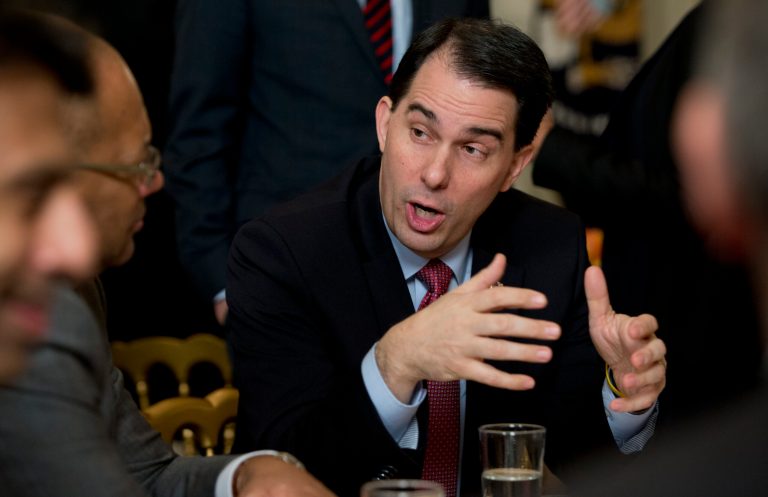 Wisconsin Gov. Scott Walker talks to people at his table before President Barack Obama arrives to speaks to members of the National Governors Association, Monday, Feb. 23, 2015, in the State Dining Room of White House in Washington. (AP Photo/Carolyn Kaster)