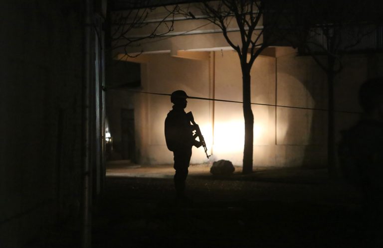 A member of the Afghan security forces stands guard at the site of a suicide attack targeting parliamentarian Gul Pacha Mujedi in Kabul, Afghanistan, Sunday, March 29, 2015. (AP Photo/Rahmat Gul)