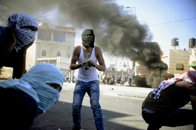 A Palestinian holds a Molotov cocktail during clashes with Israeli border police in Jerusalem on Wednesday, July 2, 2014. The suspected abduction of an Arab teen followed by the discovery of a body in Jerusalem on Wednesday ignited clashes between Israeli police and stone-throwing Palestinians, who saw it as a revenge attack for the killing of three Israeli teens in the West Bank. (AP Photo/Mahmoud Illean)