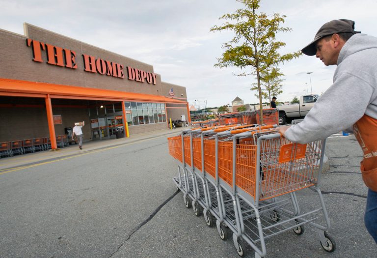 A Home Depot employee pushes carts. 