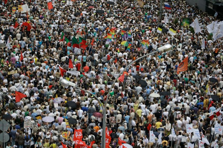   Demonstrators hold various flags as they gather during a massive protest against Putin's rule in Moscow, Tuesday, June 12, 2012. Thousands of Russians are gathering Tuesday for the first massive protest against President Vladimir Putin's rule since his inauguration as investigators summoned several key opposition figures for questioning in an apparent bid to disrupt the rally.(AP Photo/Mikhail Metzel)  
