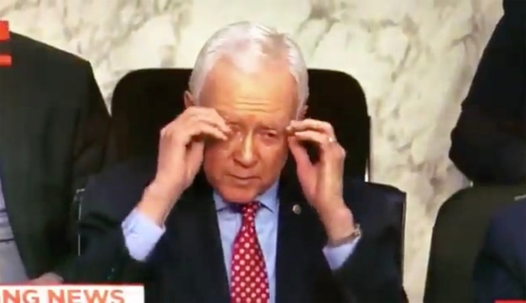 Orrin Hatch is seen going through the motions of removing a pair glasses that didn't exist while questioning Homeland Security Secretary Kirstjen Nielsen, which caught the eye of Twitter users tuned into the hearing. (Image courtesy screenshot)