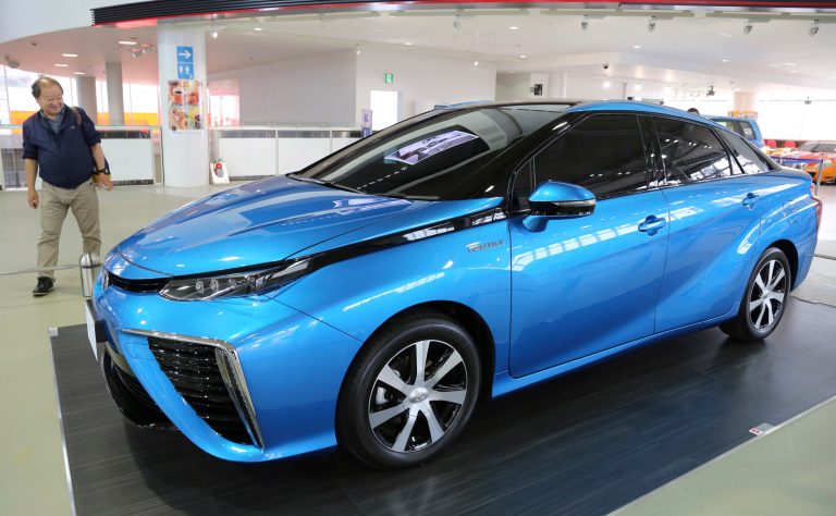 In this June 26, 2014 photo, a visitor looks at Toyota Motor's new fuel cell vehicle (FCV) on display at the company's showroom in Tokyo. Buoyed by its success with electric-gasoline hybrid vehicles, Toyota is betting that drivers will embrace hydrogen fuel cells, an even cleaner technology that runs on the energy created by an electrochemical reaction when oxygen in the air combines with hydrogen stored as fuel. (AP Photo/Koji Sasahara)