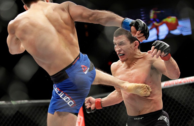 Henry Cejudo kicks Joseph Benavidez during a mixed martial arts flyweight bout Saturday, Dec. 3, 2016, in Las Vegas. (AP Photo/John Locher)